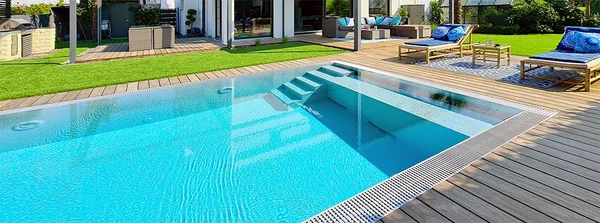 Fertiger Pool mit Holzterrasse und Liegen im Garten