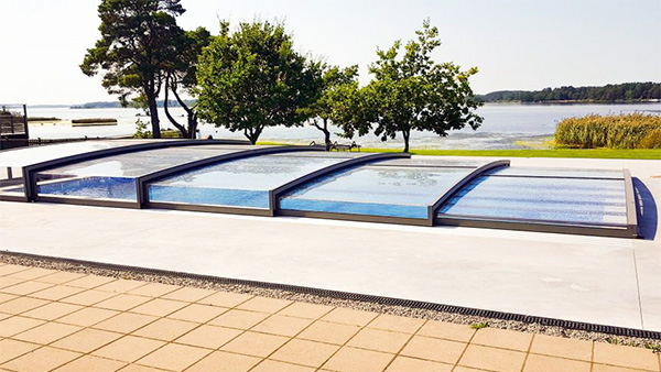Flache Schwimmbadüberdachung Aluna® Exclusive Line in moderner Gartenumgebung Flache Schwimmbadüberdachung Aluna® Exclusive Line in moderner Gartenumgebung