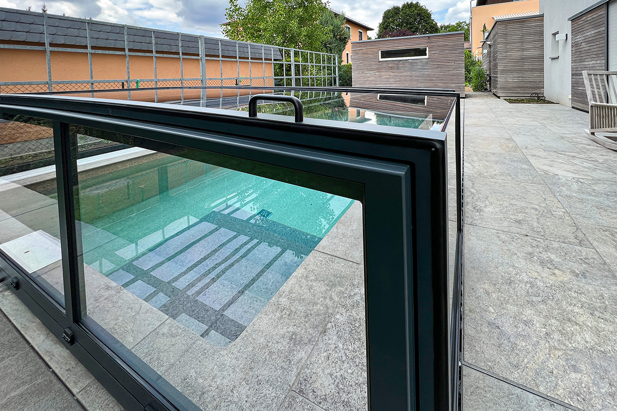 Detailansicht der Aluna® Exclusive Line R1 Poolüberdachung mit geöffnetem Segment und Griff