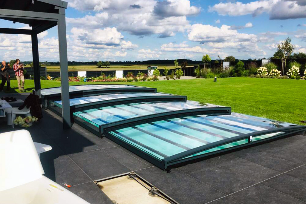 Aluna Poolüberdachung Exclusive Line R1 flach, halb geöffnet auf dunklen Terrassenplatten