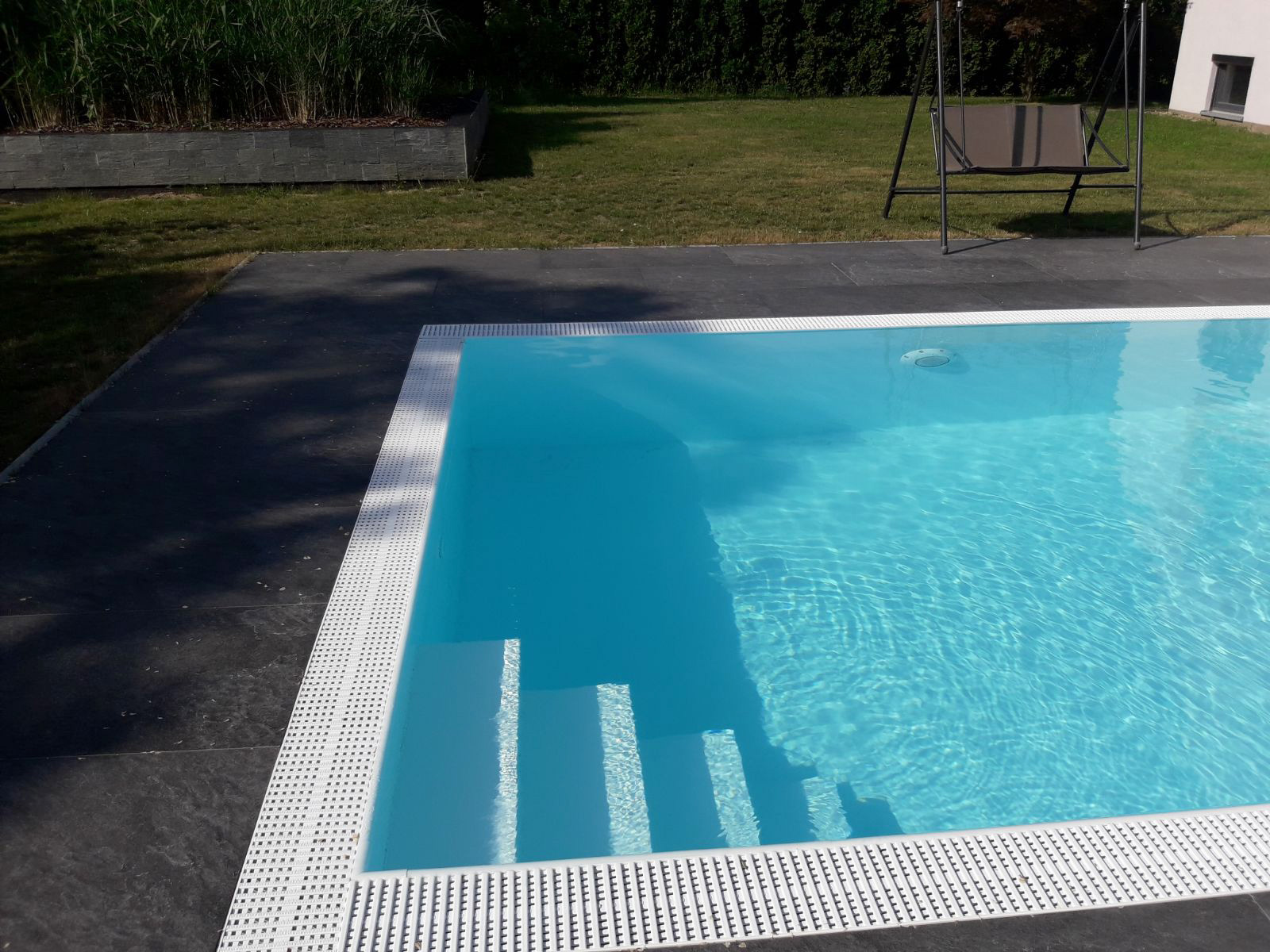 Weiße Ecktreppe und Überlaufrinne des Albixon G2 Polypropylen Pools im Detail