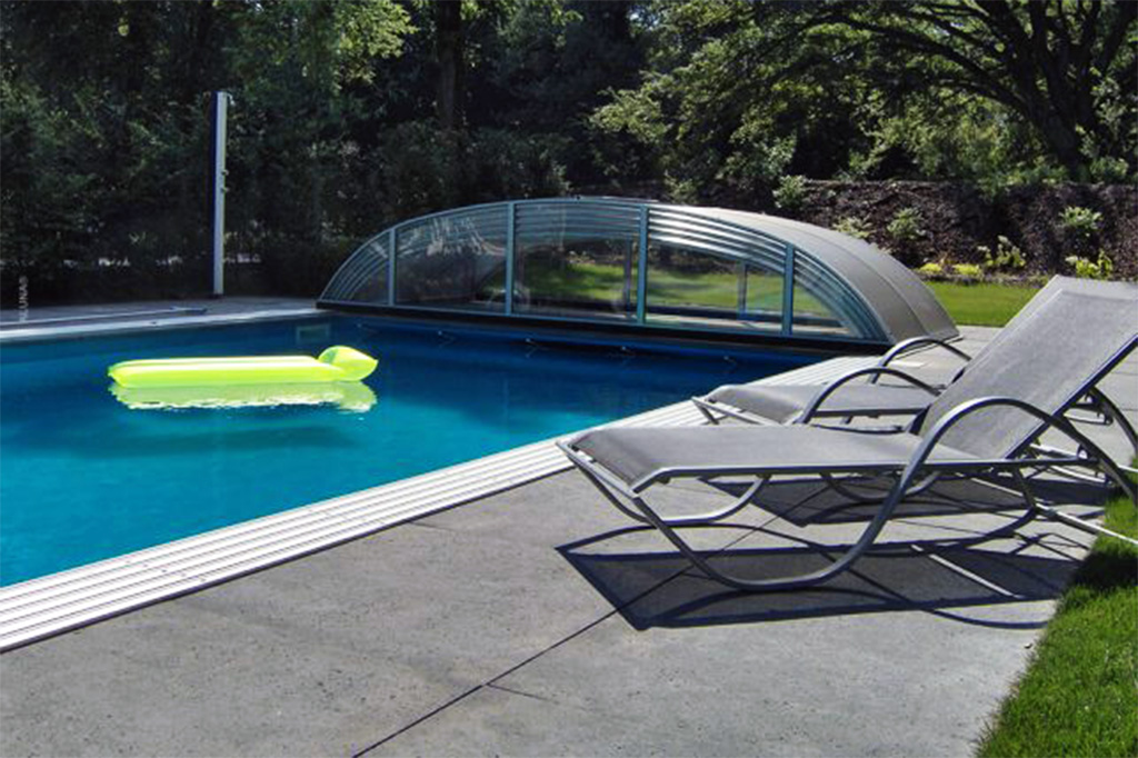 Poolüberdachung Aluna Atlanta flach über einem Pool mit Liegen und Schwimminsel
