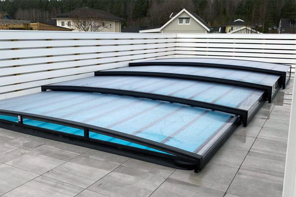 Flache Poolüberdachung Aluna Exclusive Line R1 mit dunklem Rahmen und transparenten Segmenten auf Terrasse