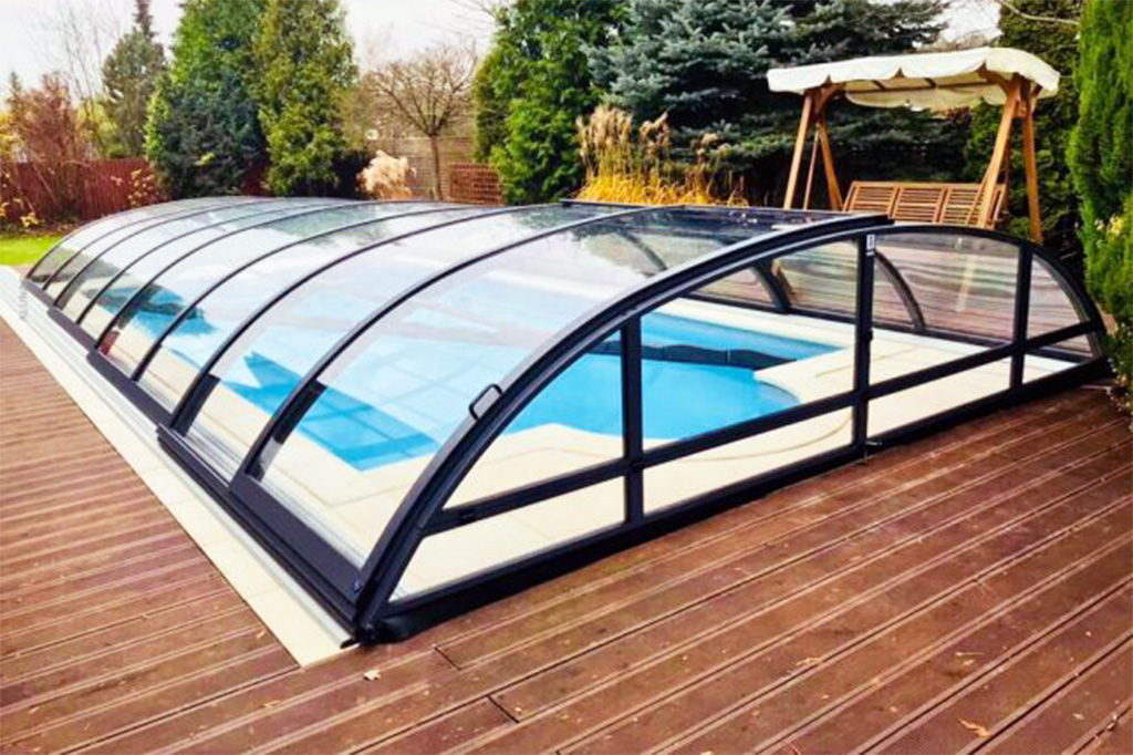 Poolüberdachung Aluna Atlanta mit transparenten Segmenten und schwarzem Rahmen auf Holzterrasse
