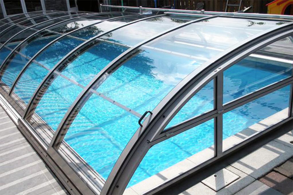 Detailansicht der transparenten Poolüberdachung Aluna Atlanta mit Aluminiumrahmen und blauer Poolfolie