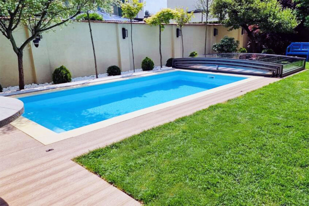Flache Poolüberdachung Aluna Exclusive Line R1 über einem rechteckigen Pool im Garten