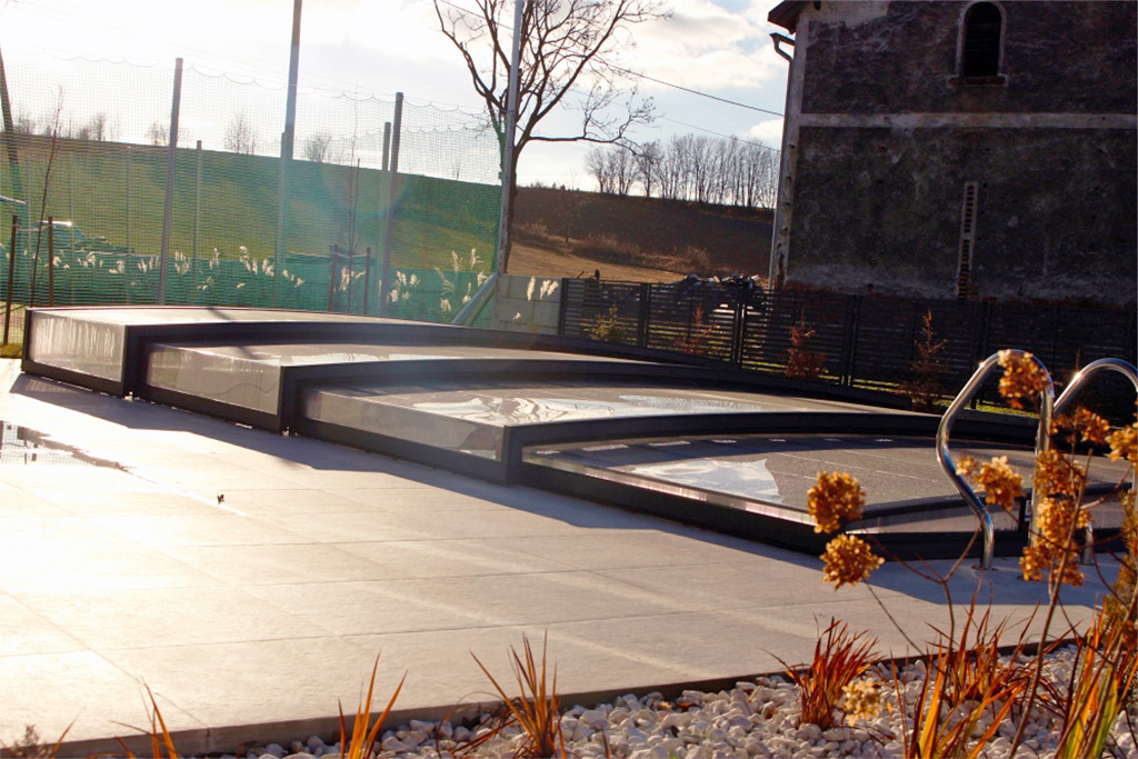 Detailansicht der flachen Poolüberdachung Aluna® Exclusive Line R1 auf einer Terrasse mit Poolleiter.