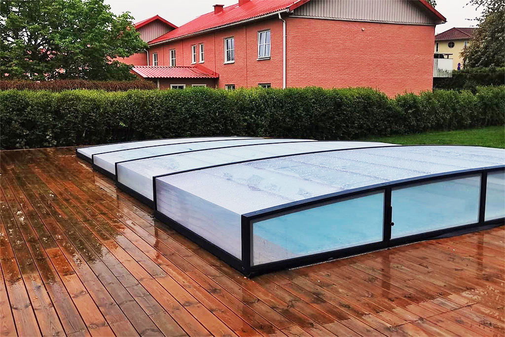 Flache Poolüberdachung Aluna® Exclusive Line R1 auf Holzterrasse mit Wassertropfen nach Regen