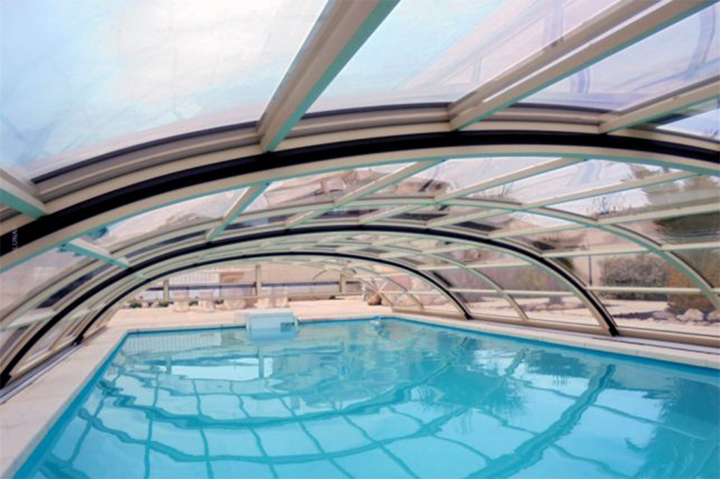 Detailansicht der transparenten, flachen Poolüberdachung Aluna Atlanta über einem blauen Pool