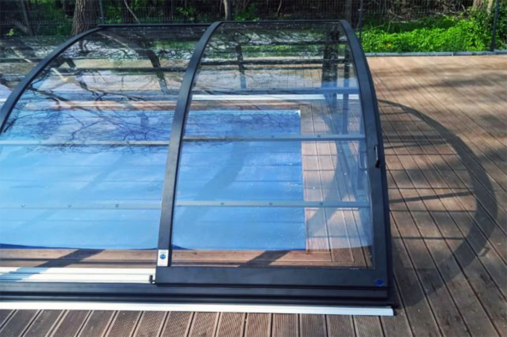 Detailansicht der Aluna Poolüberdachung Atlanta mit Schienen und transparenten Segmenten auf Holzterrasse