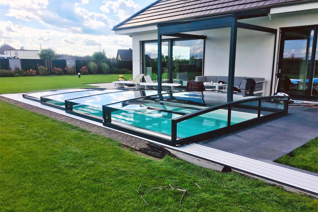 Poolüberdachung Aluna Exclusive Line R1, flach, mit Schiebeelementen und schwarzem Rahmen am Poolrand