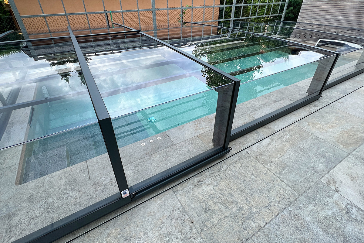 Detailansicht der Poolüberdachung Aluna Exclusive Line R1 mit transparenten Segmenten und dunklem Rahmen